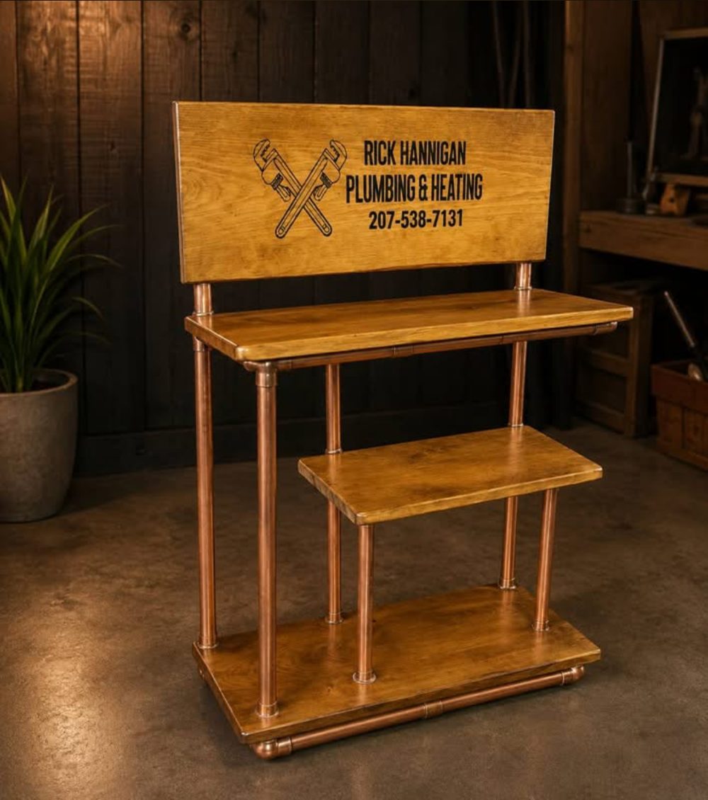 Copper pipe display stand with three wood shelves and an engraved wood sign for a plumbing and heating company